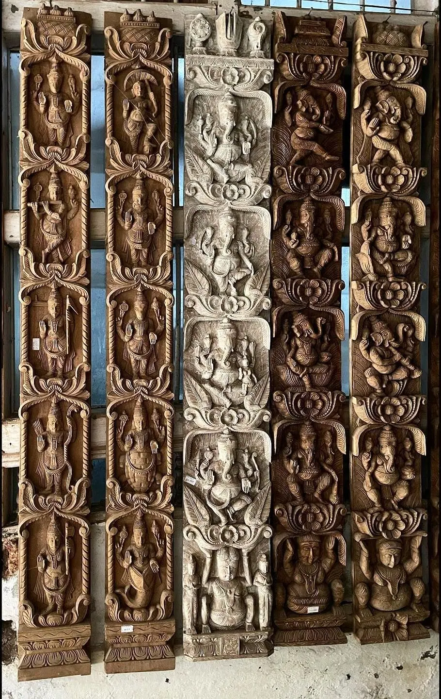Tall carved wooden temple panels with rows of figures